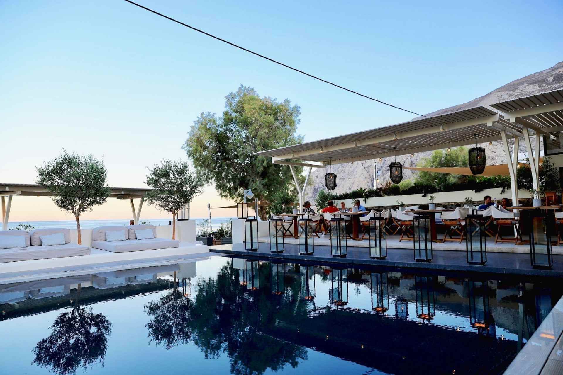 Restaurantomr&aring;de ved basseng med dempet belysning og sj&oslash;utsikt ved Bellonias Villas p&aring; Santorini