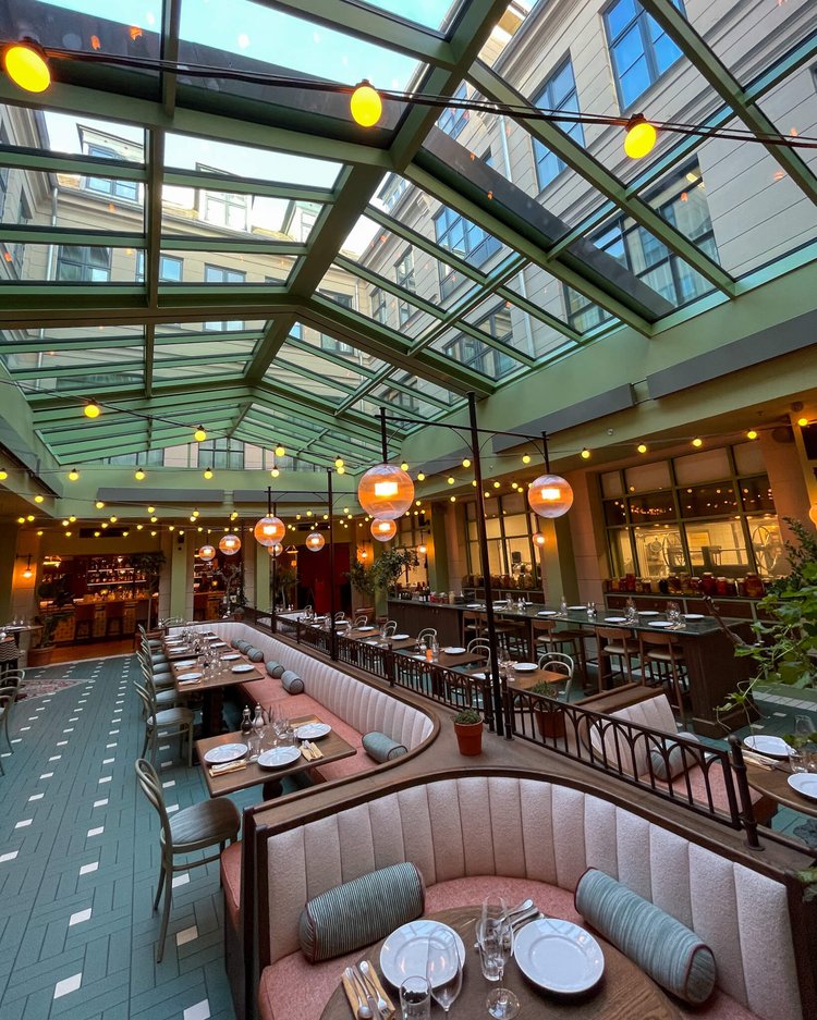 Restaurant med glasstak som slipper inn mye lys. 
