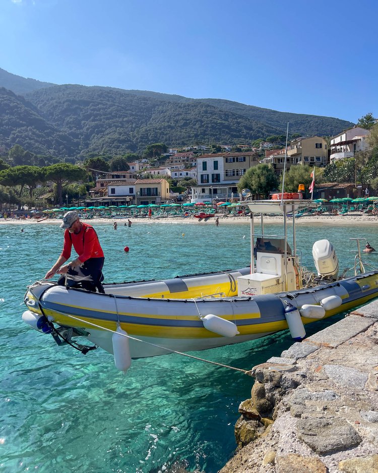 Stranden i Capo Sant Andrea Elba i bakgrunn og en rib i forgrunnen. 