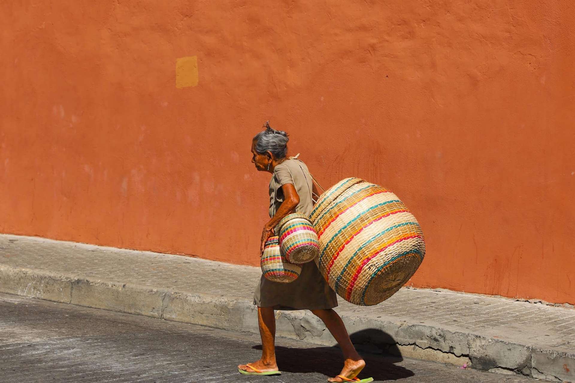 Lokal kvinne i gamlebyen i Cartagena som b&aelig;rer tradisjonelle kurver, Colombia