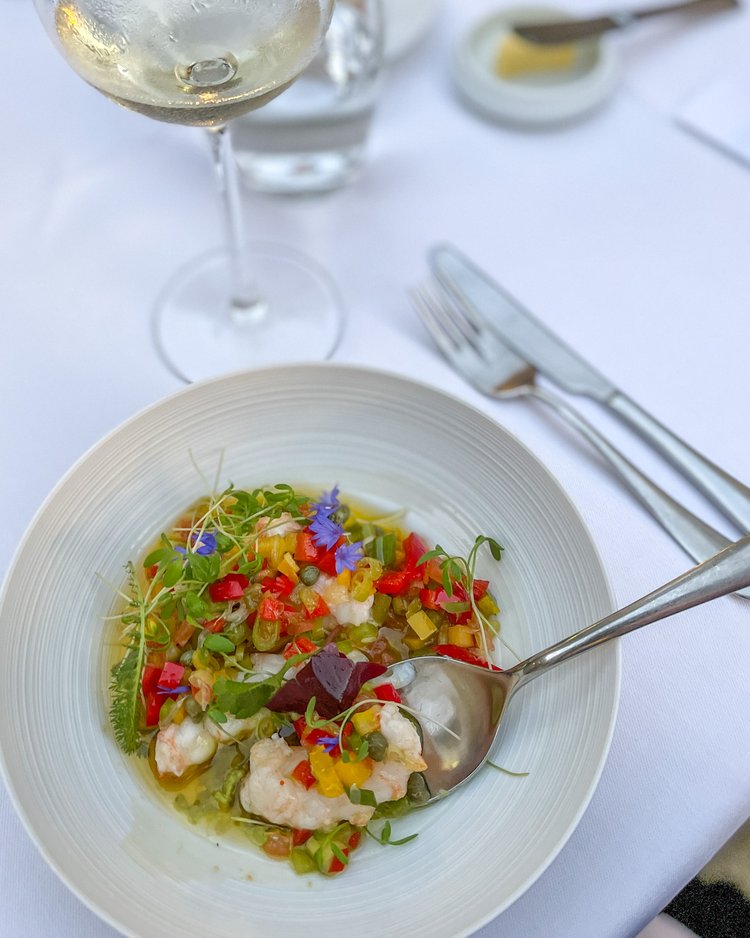 Fargerik rett med reker og grønnsaker på restaurant. 