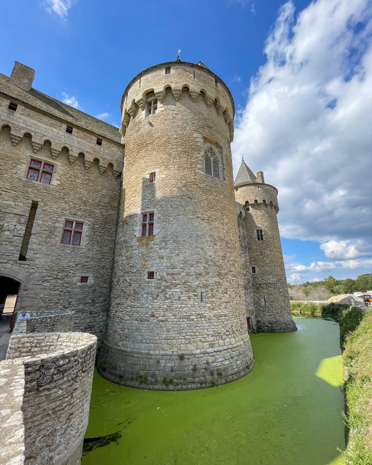 Slott med vollgrav i Bretagne. Vannet i vollgraven er grønt av alger. 