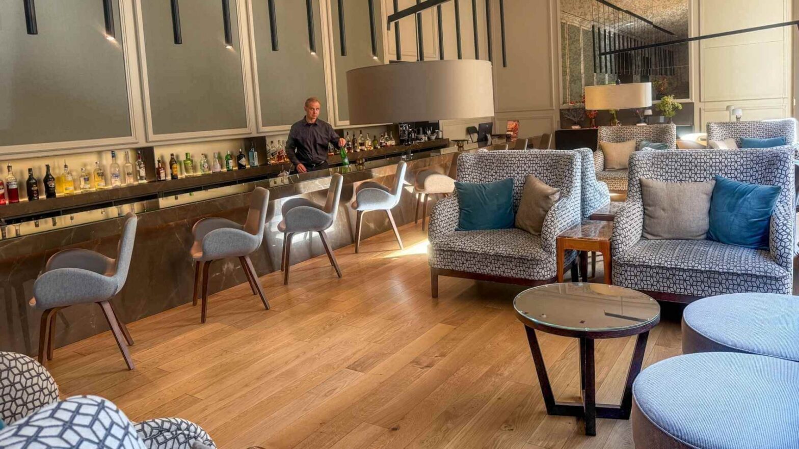 Baren p&aring; BoHo Hotel i Praha med marmordisk, h&oslash;ye stoler og sittegrupper i bl&aring; og gr&aring; toner.