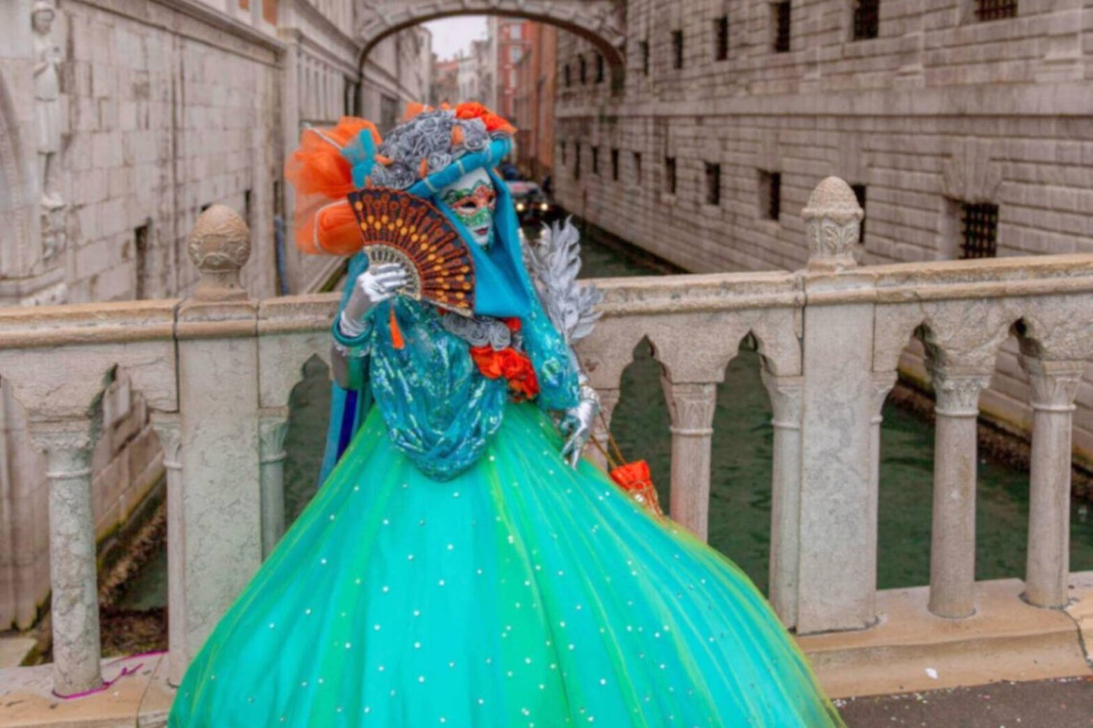 Turkis kostyme og maske under karneval i Venezia ved kanal og bro.