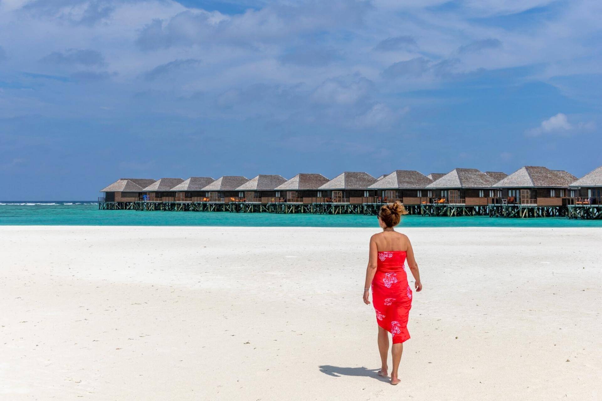 Strand og overwater-villaer p&aring; Meeru Island Resort & Spa p&aring; Maldivene, med turkist hav og kritthvit sandstrand