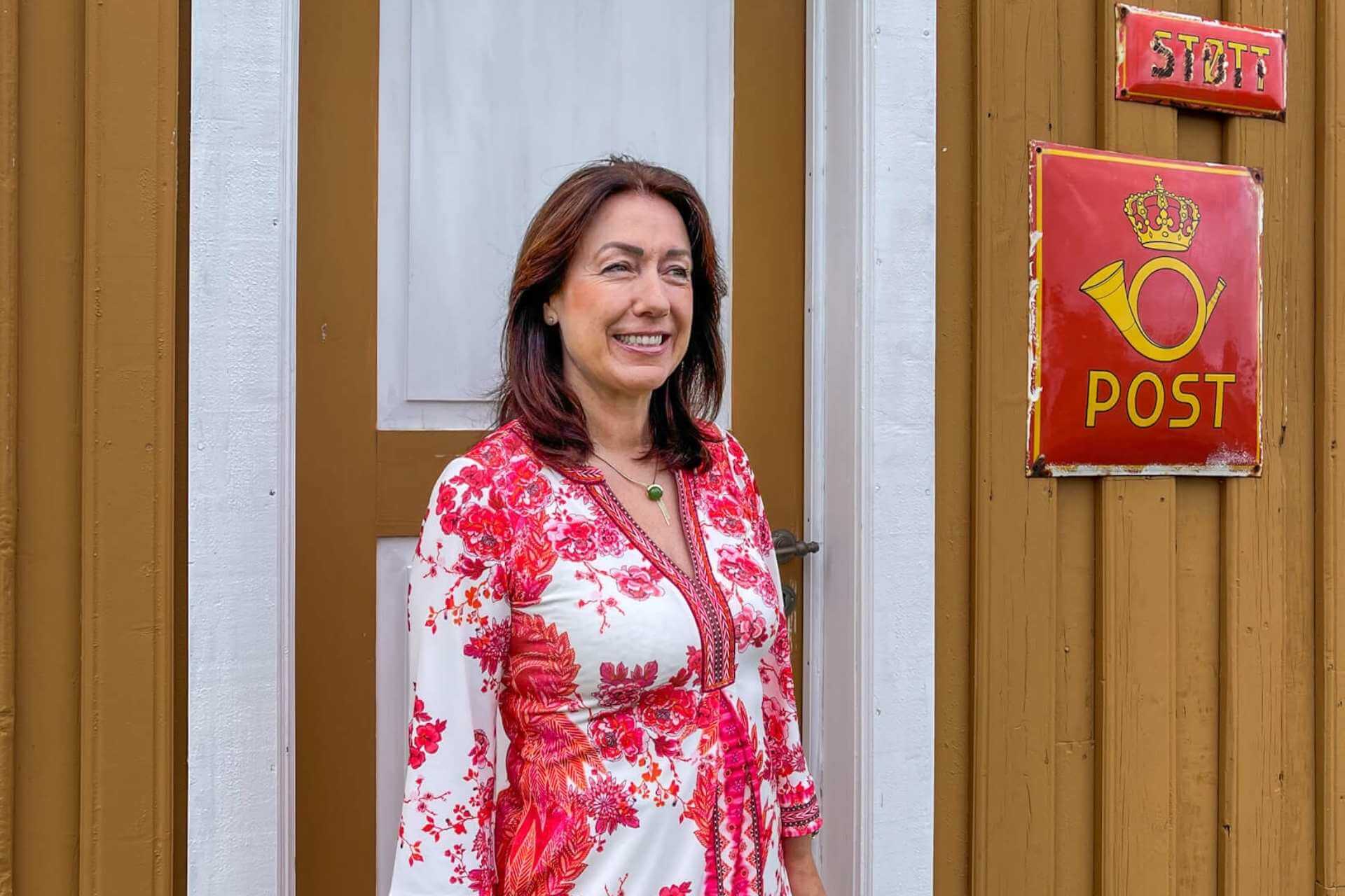 Historisk postskilt på vegg ved gammelt handelssted på Helgelandskysten.