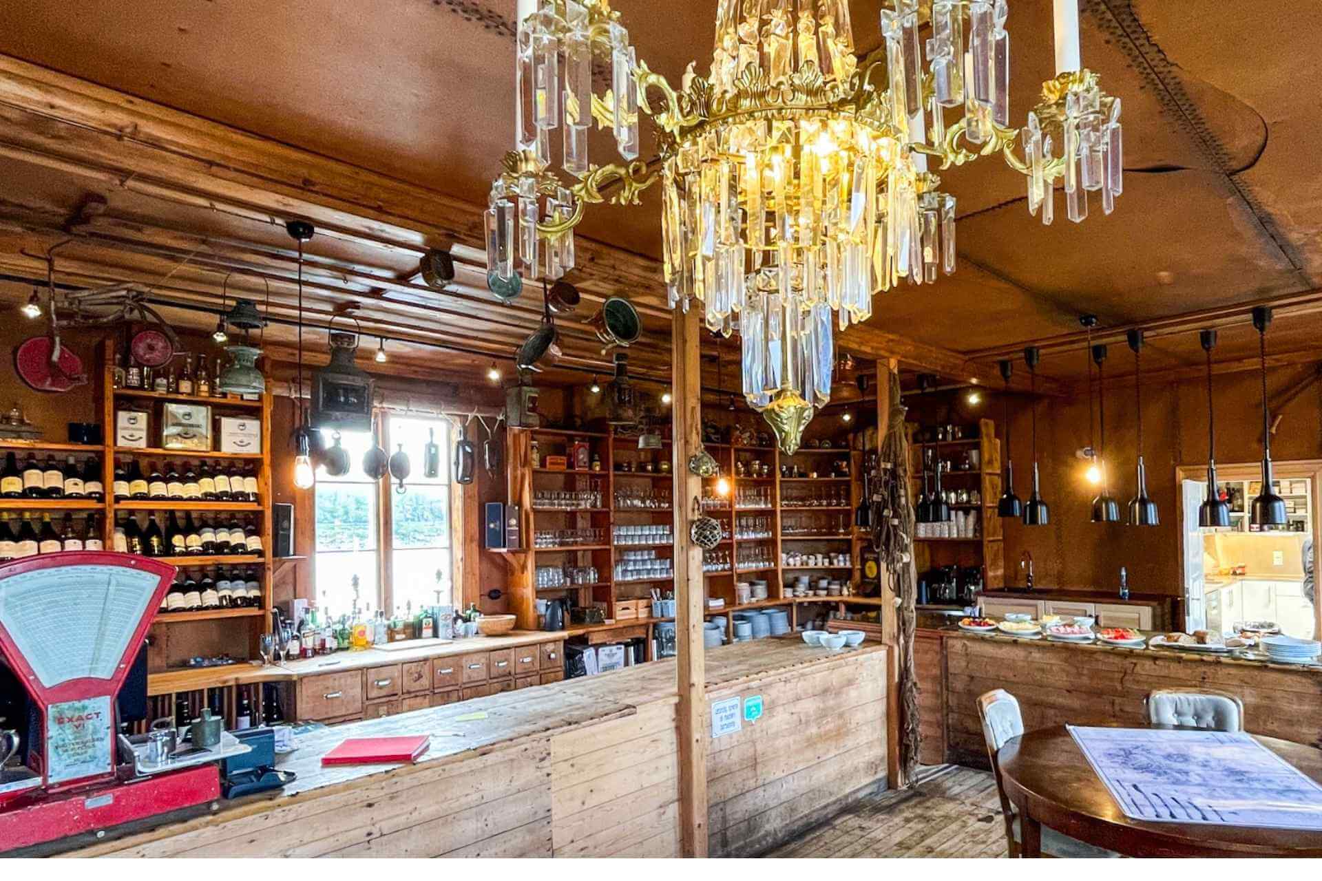 Historisk restaurant med åpent kjøkken, treverk og stemningsfull belysning.