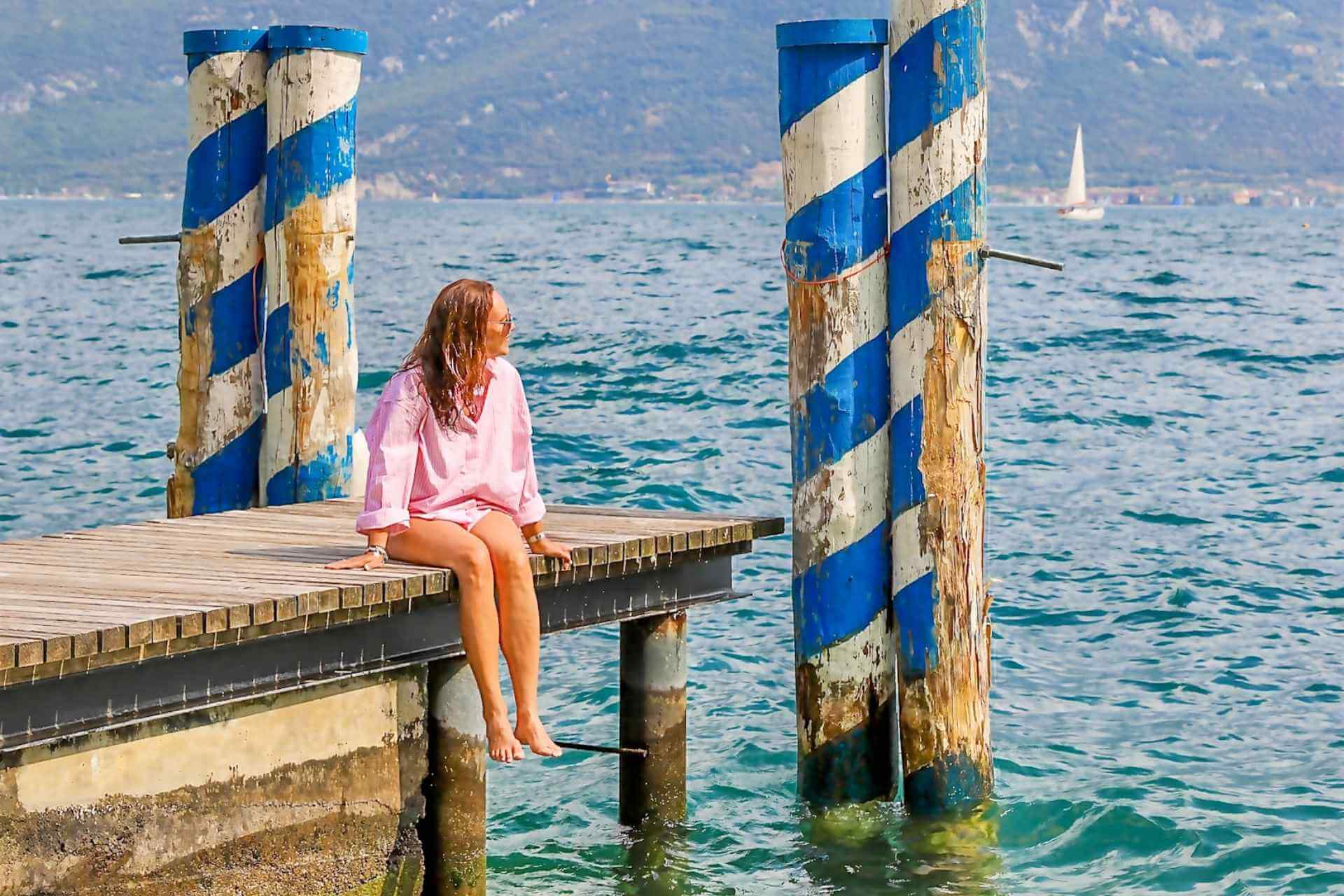 Stemningsbilde ved Gardasj&oslash;en med brygge og klart vann i Italia