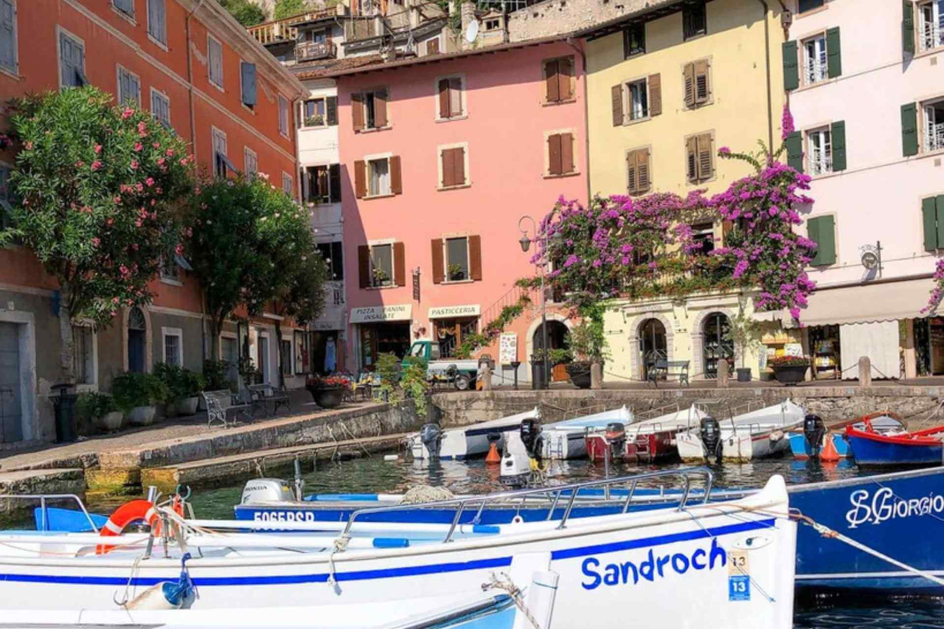 Sm&aring; b&aring;ter og pastellfargede hus i Limone sul Garda. 