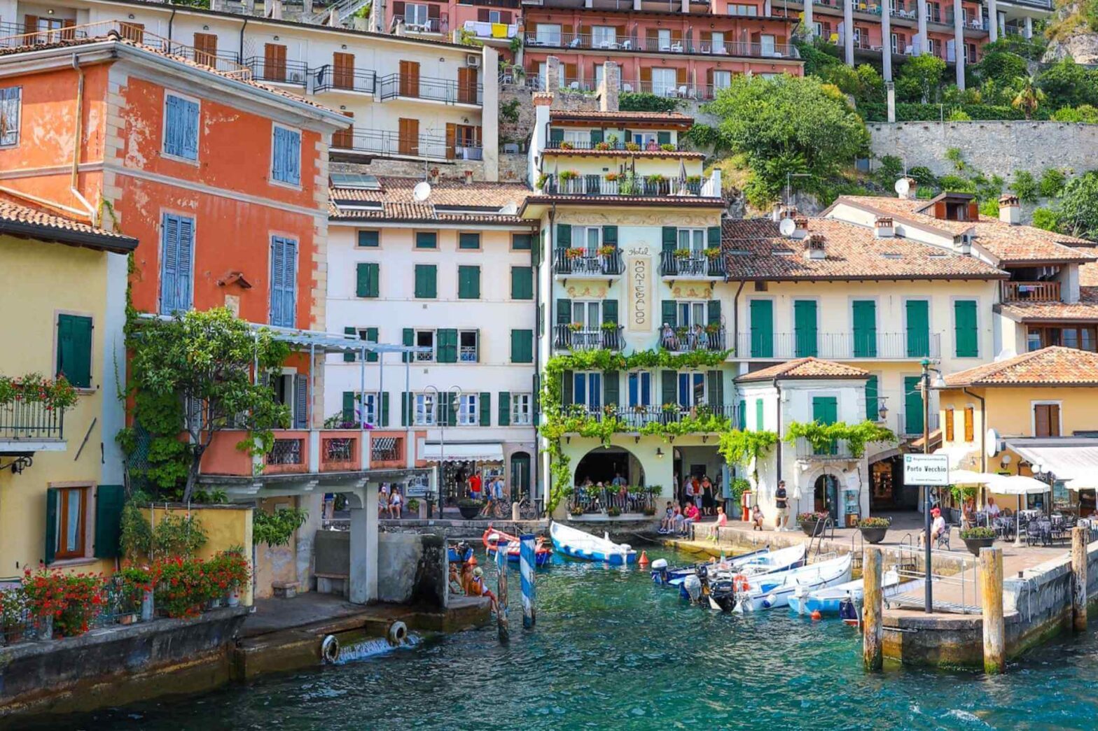 Limone sul Garda sett fra Gardasjøen med hus i fjellsiden og promenade ved vannet