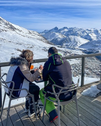 Et par nyter en drink med utsikt over fjellene i Frankrike.