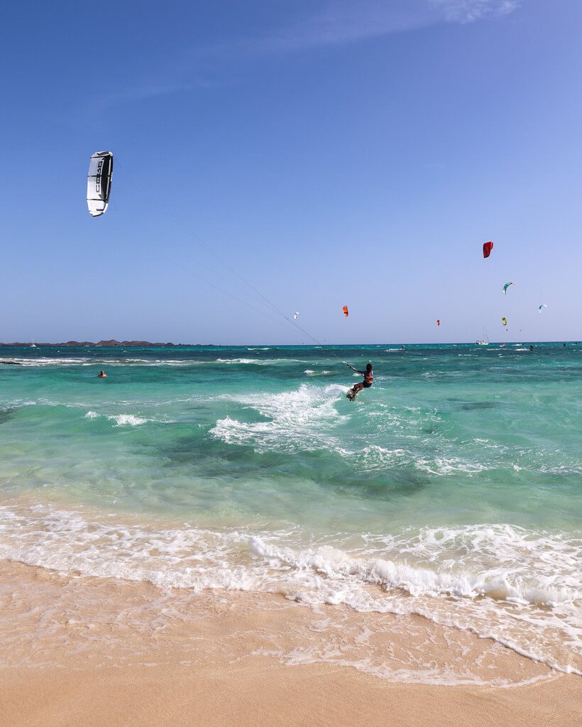 Kitere på stranden på Fuerteventura. Lys og fin sandstrand, turkist hav og blå himmel. 