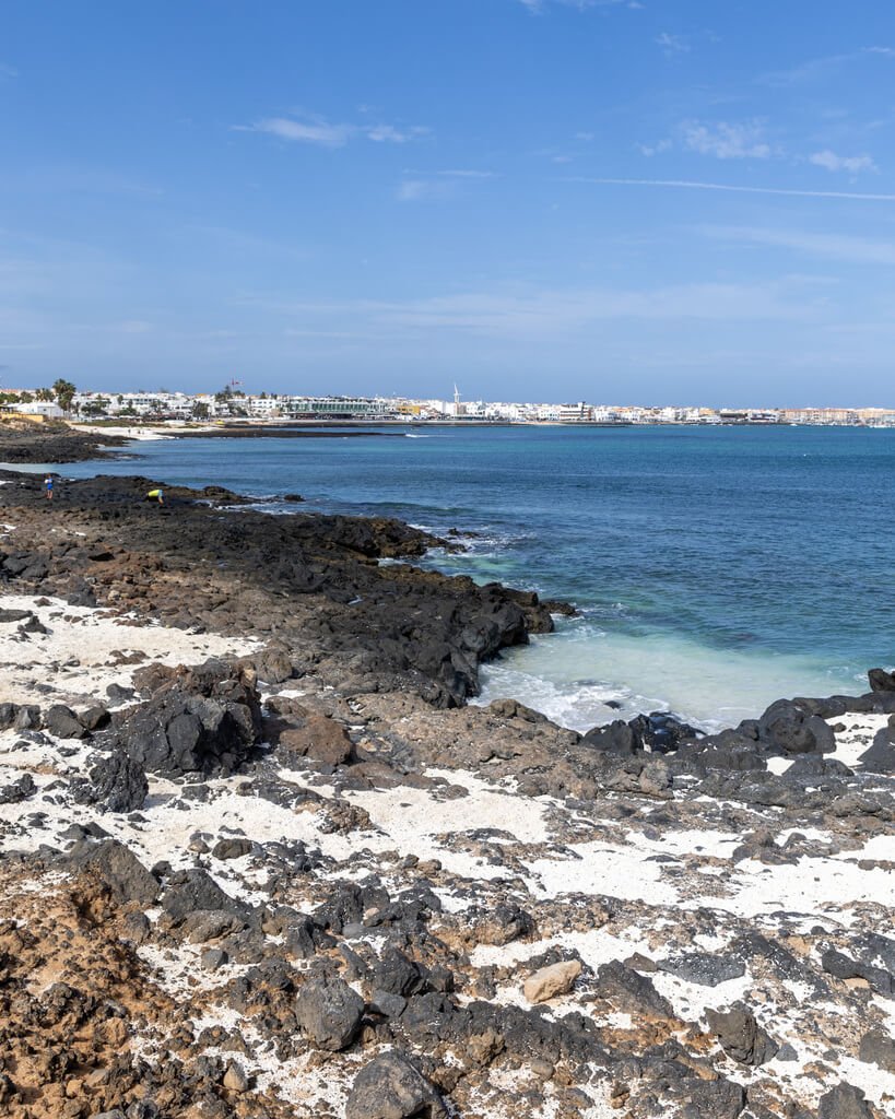 En av de mange små strendene hvor sanden ser ut som popcorn beach ved Corralejo på Fuerteventura. 