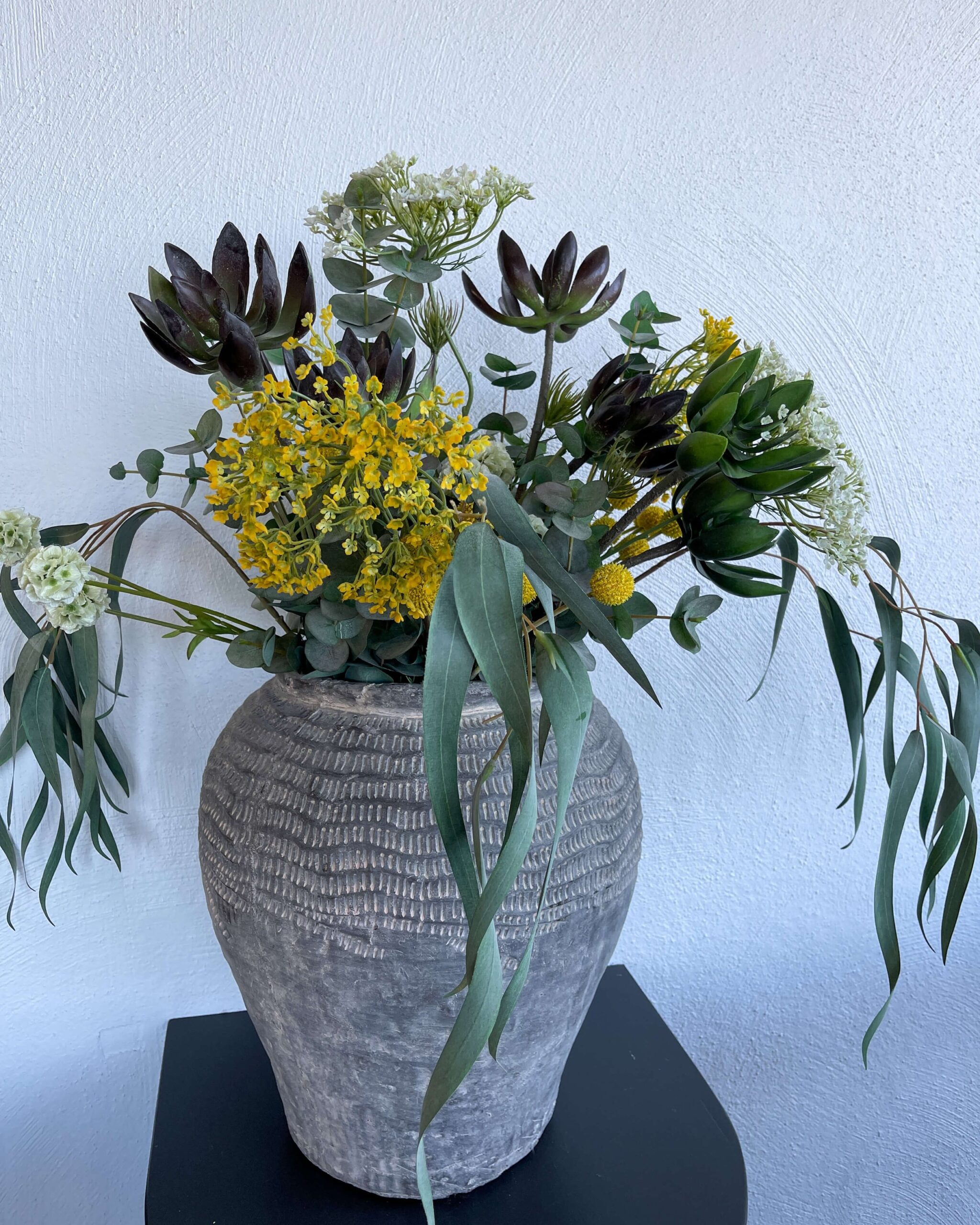 Friske blomster i en rustikk krukke pynter opp på hotellet. 