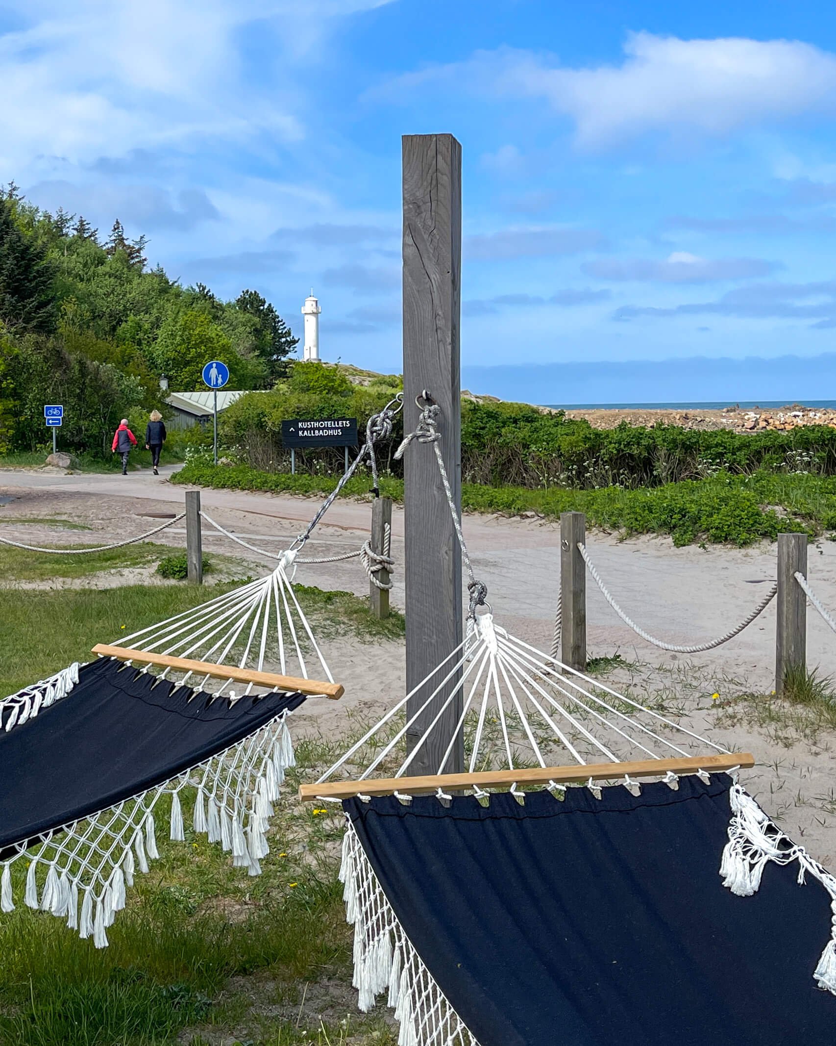 Hengekøyer på uteplassen til hotellet. I bakgrunnen ser du Subbe fyr. 