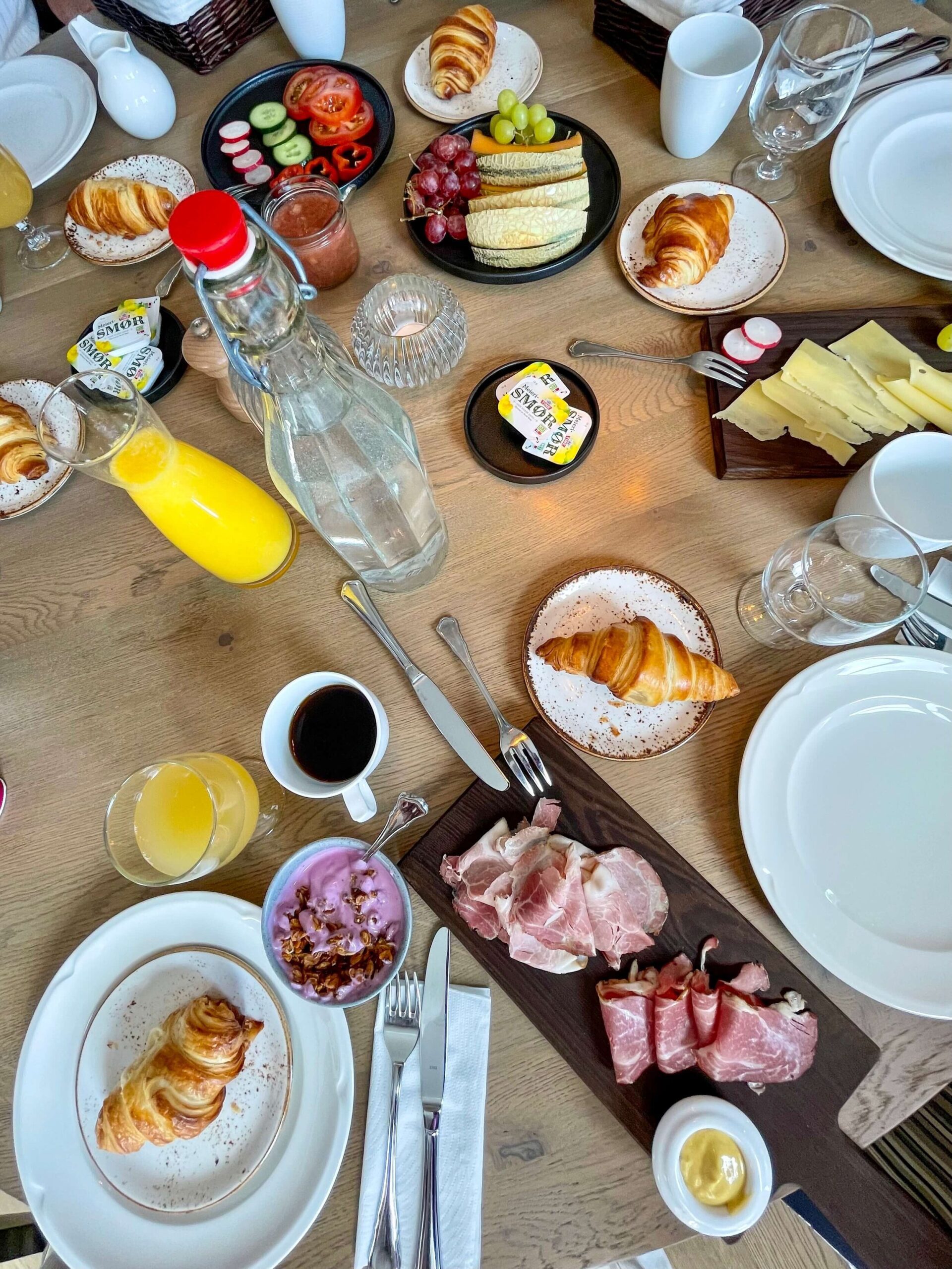 Frokostbord med ost, skinker, kaffe, juice, yoghurt, brød og smør på Skåbu Fjellhotell. 