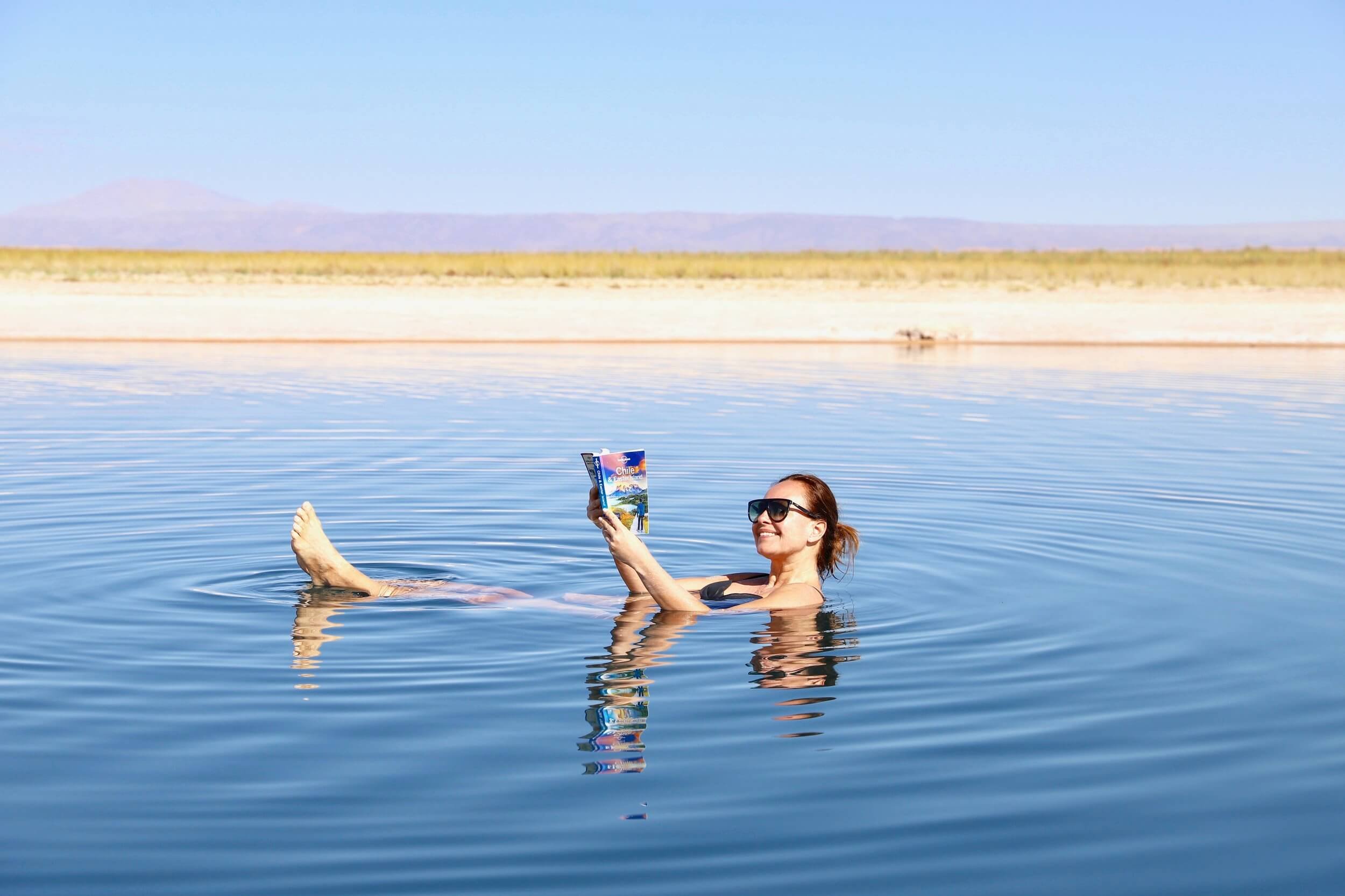 Her flyter jeg i en salt innsjø i Atacamaørkenen i Chile. Vannet er så salt at jeg flyter lett. Jeg leser i en reiseguide om Chile og smiler. Bak skimtes fjellene og den tørre ørkenen.