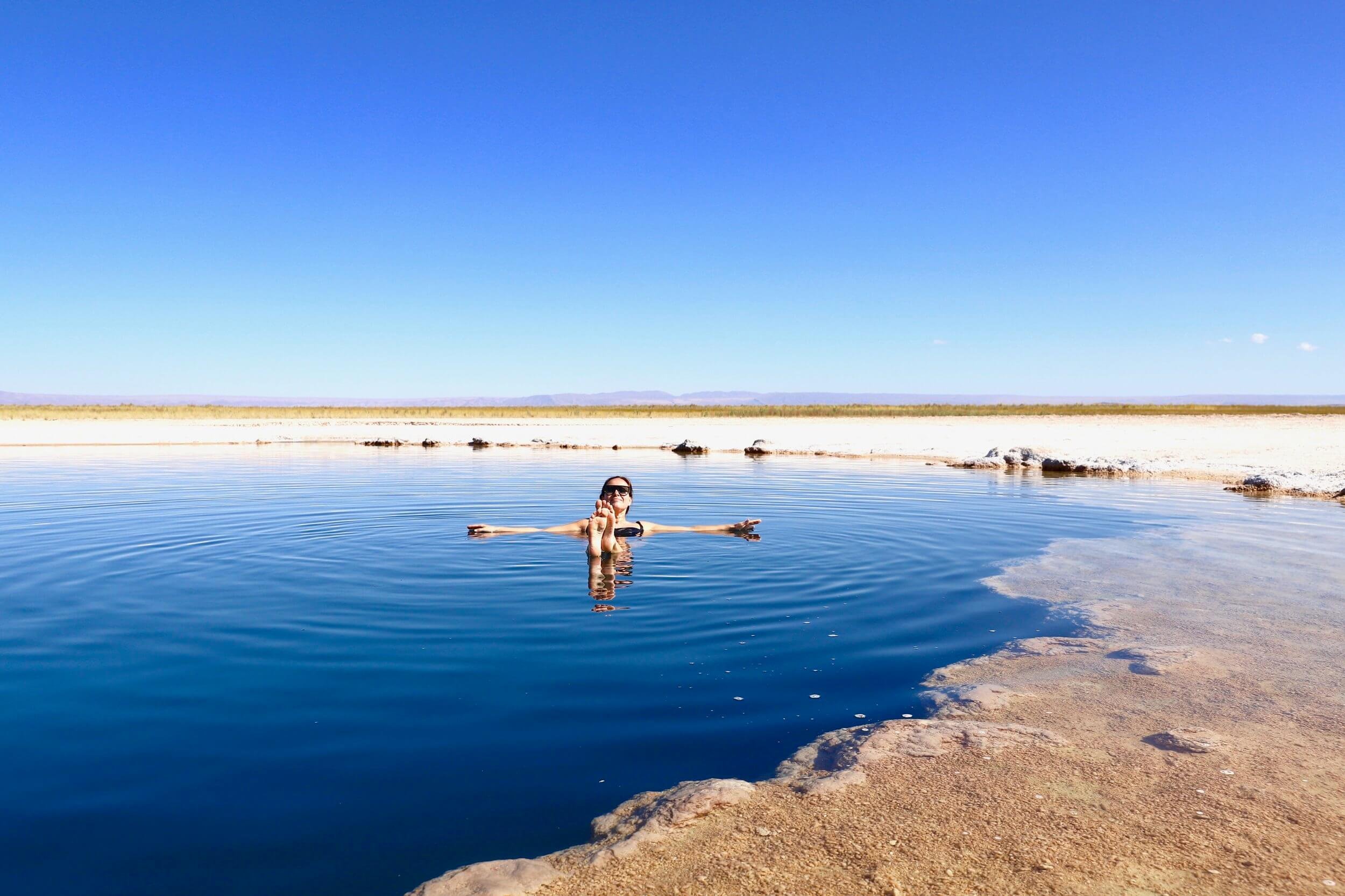 Jeg flyter i saltvann med badedrakt og solbriller på i Atacama Chile. 