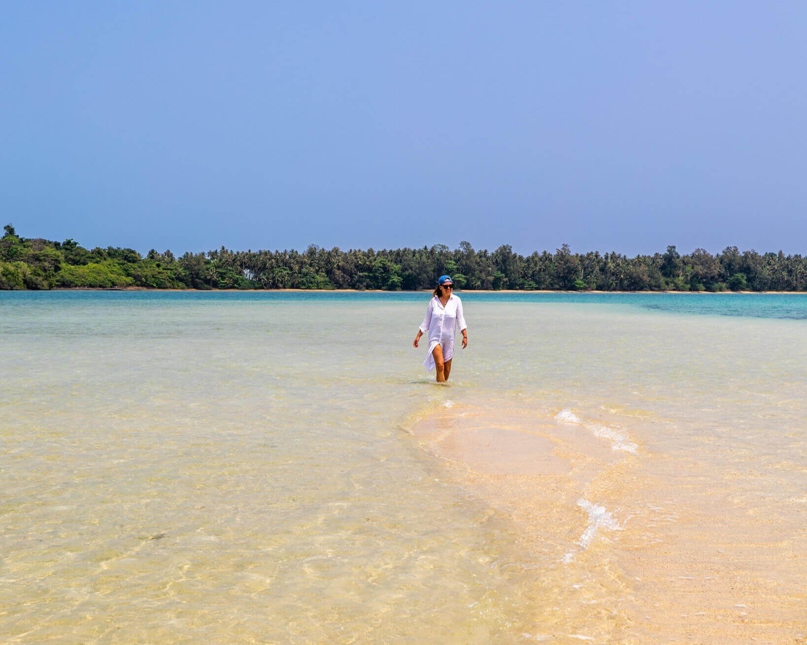 En drømmestrand i Thailand med lys sand og turkist hav.