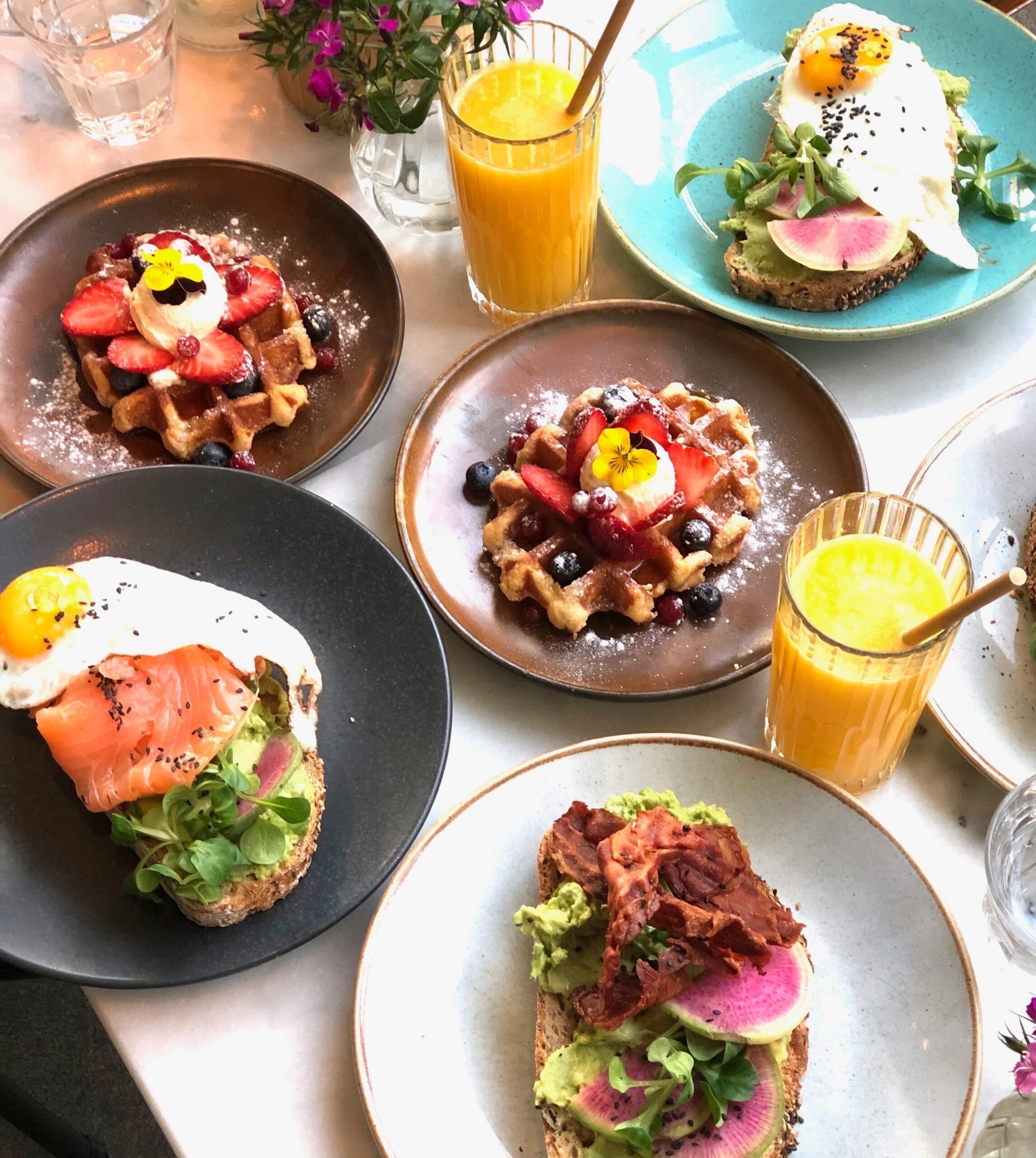 Waffles with fruit and ice cream, avocado toast with bacon, avocado toast with egg and salmon and avocado toast with egg and salad. To drink orange juice. 