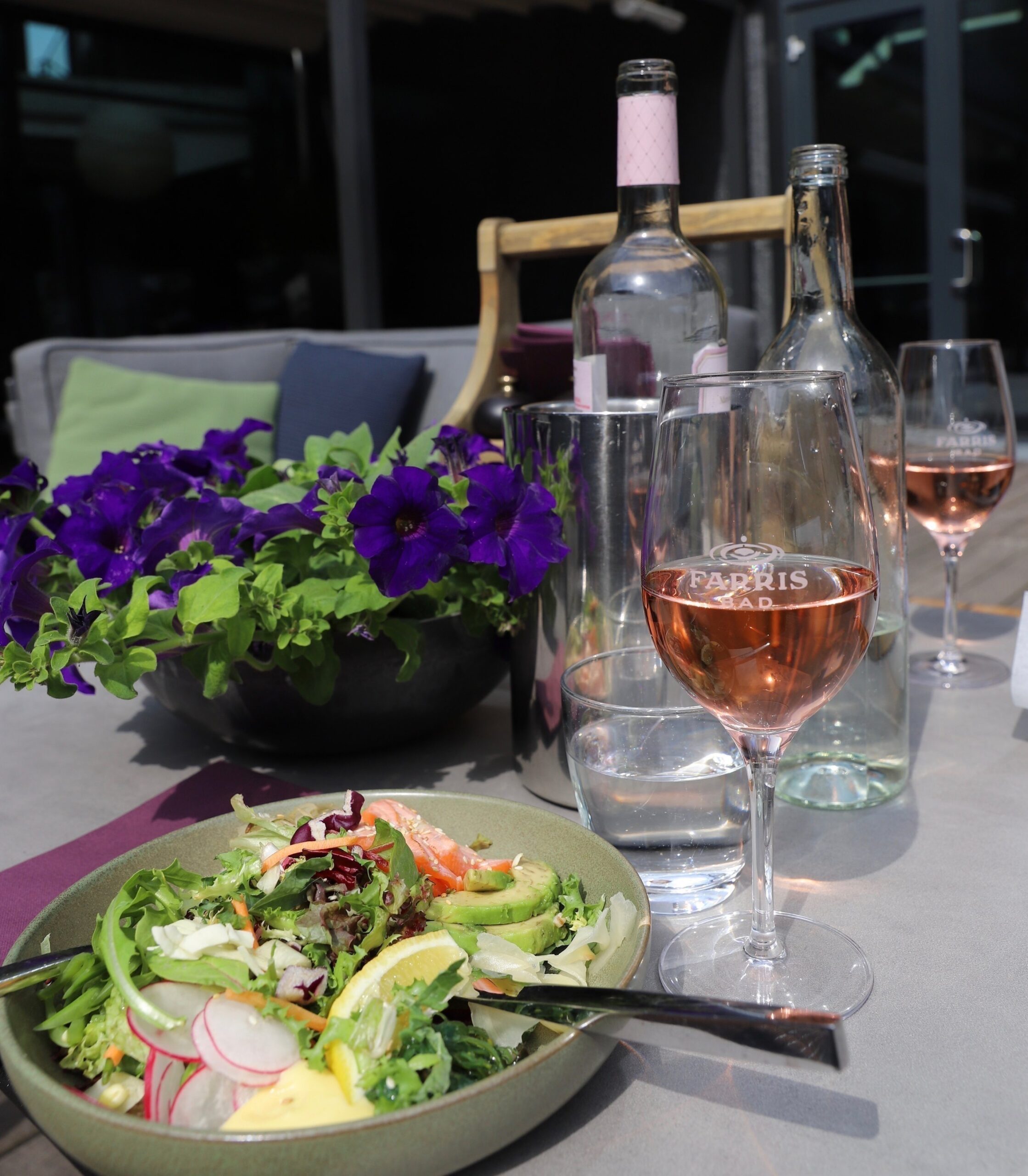 Lunch in the sun on the outdoor terrace at Farris Bad. A delicious, fresh and locally sourced salad served with rosé wine and water.