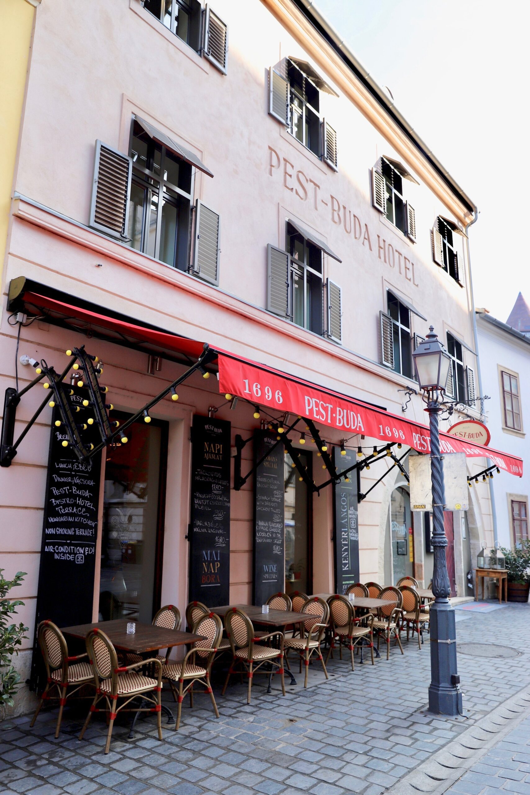 Pest Buda Hotel og restaurant. Utenfor hyggelige kafebord og stoler. 