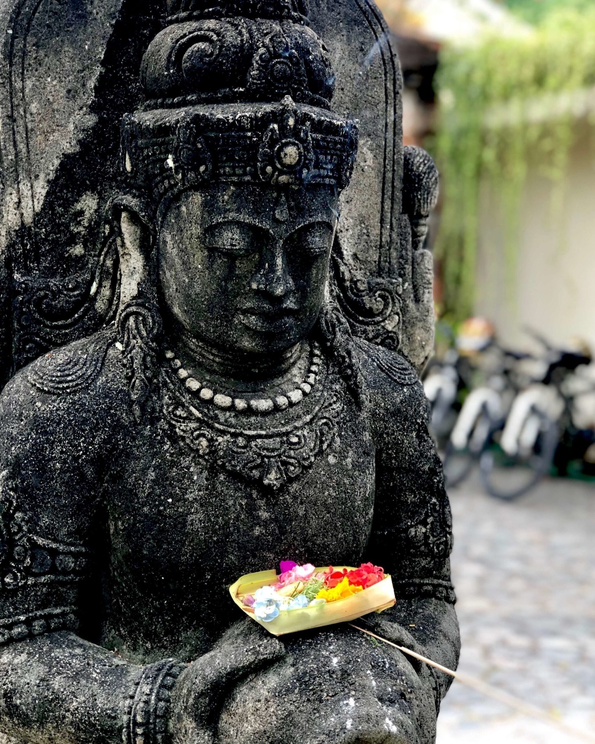 Bali traditional stature with offering of flowers. 