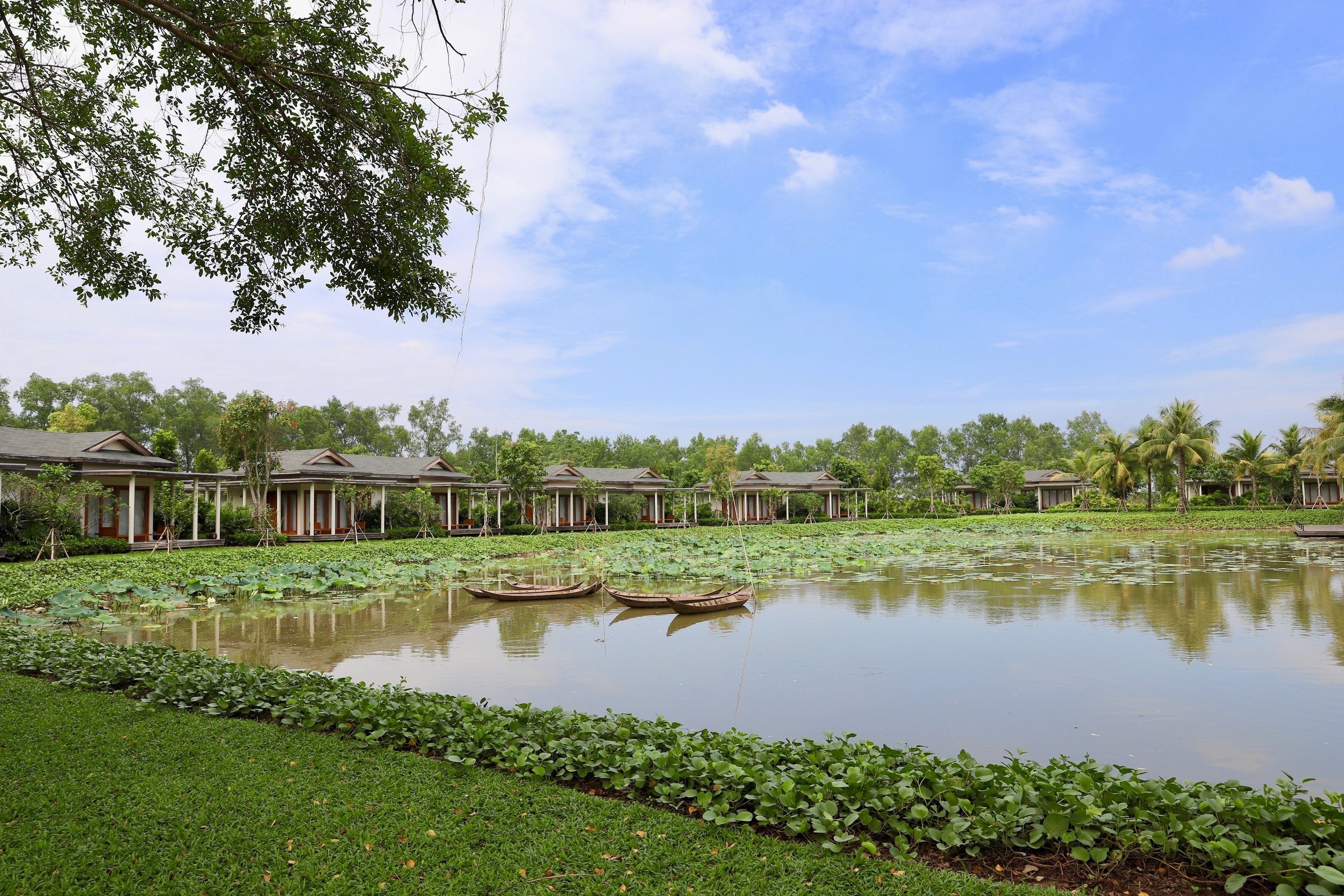 The green garden with a lake at the Azerai Can Tho Hotel Vietnam. 