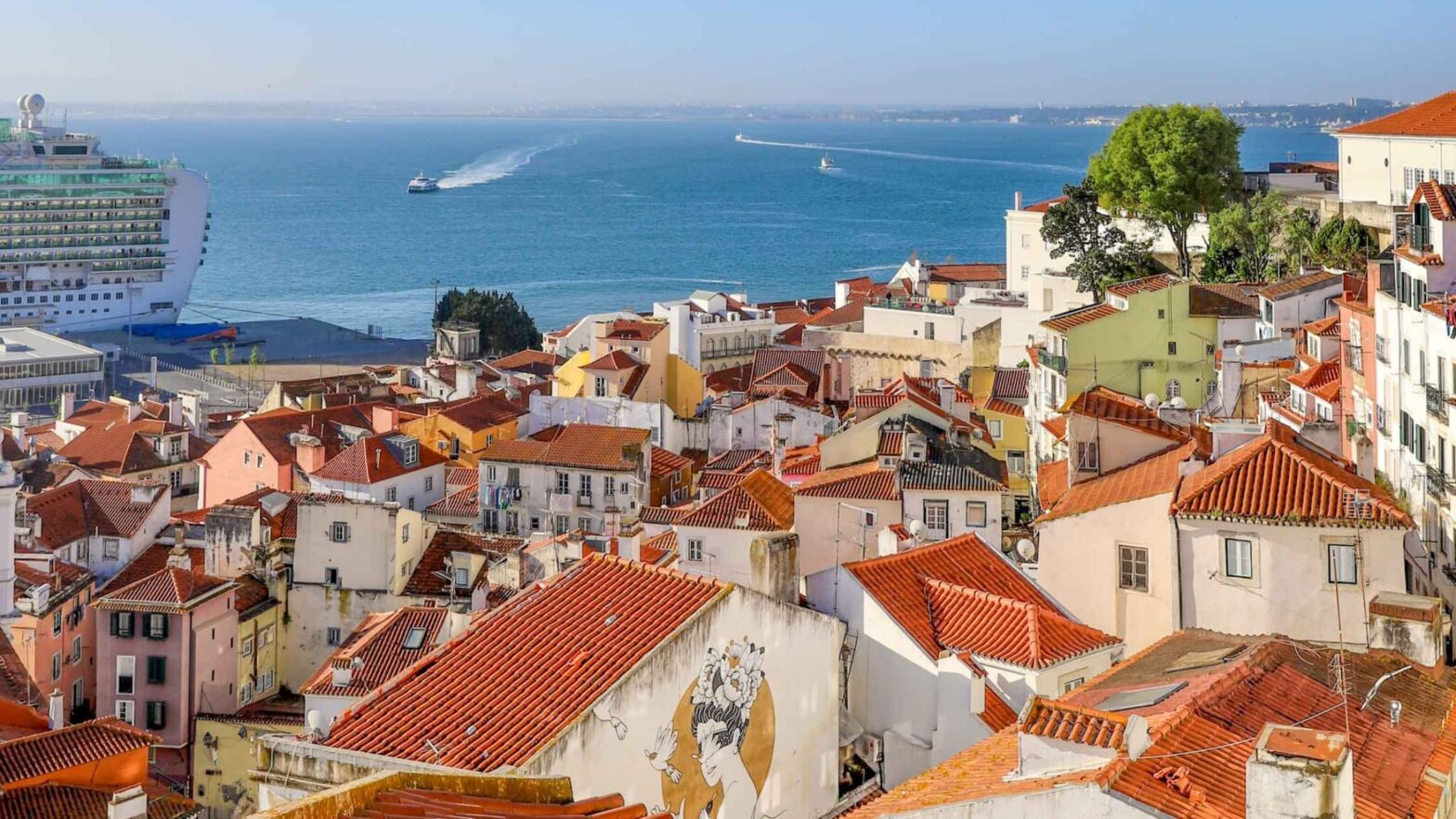 Lisboa utsikt over sjarmerende hus i Alfama og havet med båter.