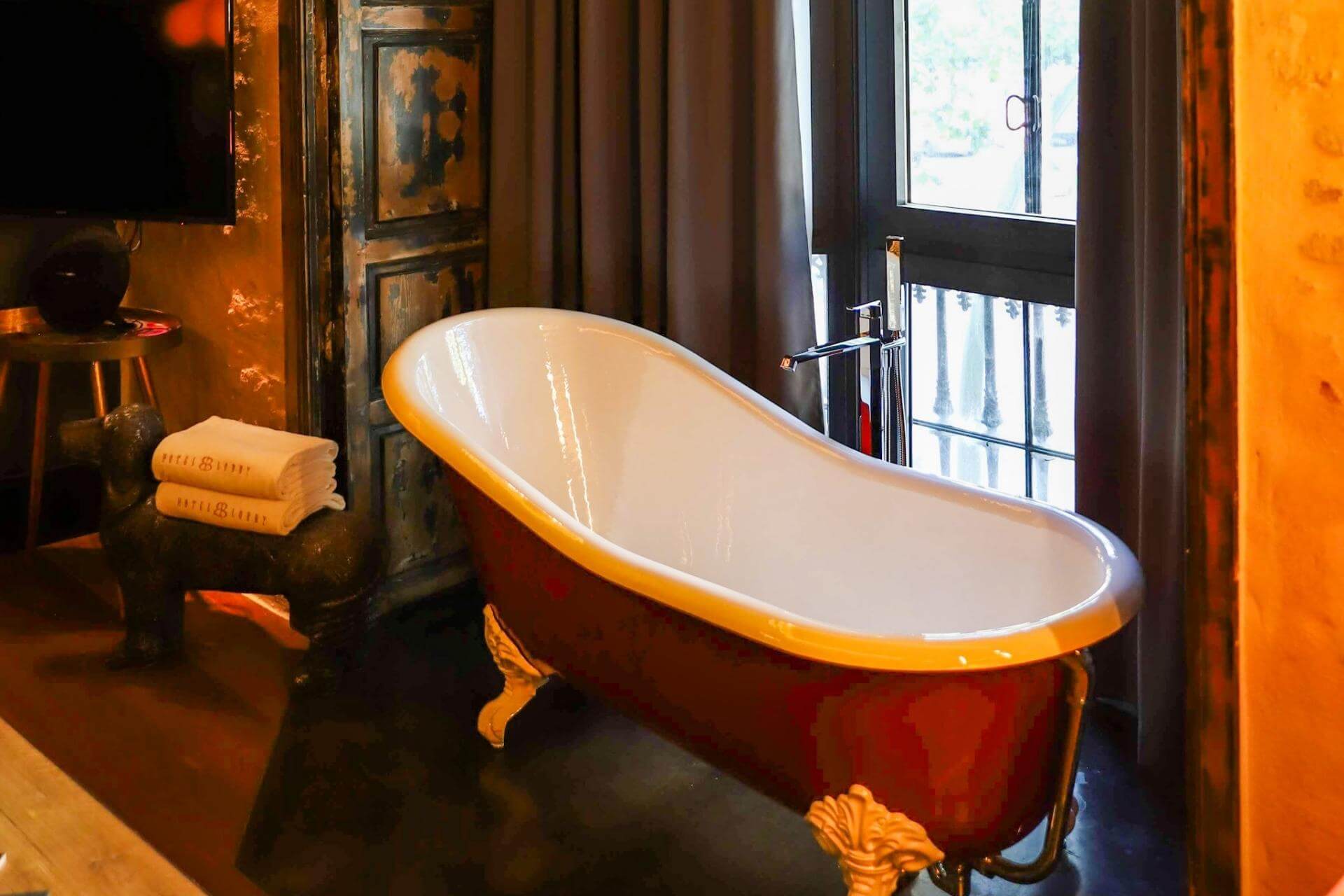 Detalj fra rom på hotell med badekar og designinteriør.