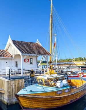 Gammel trebat og gammelt koselig hvitt hus Langesund brygge.
