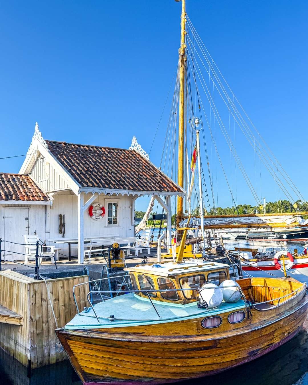 Gammel trebat og gammelt koselig hvitt hus Langesund brygge.