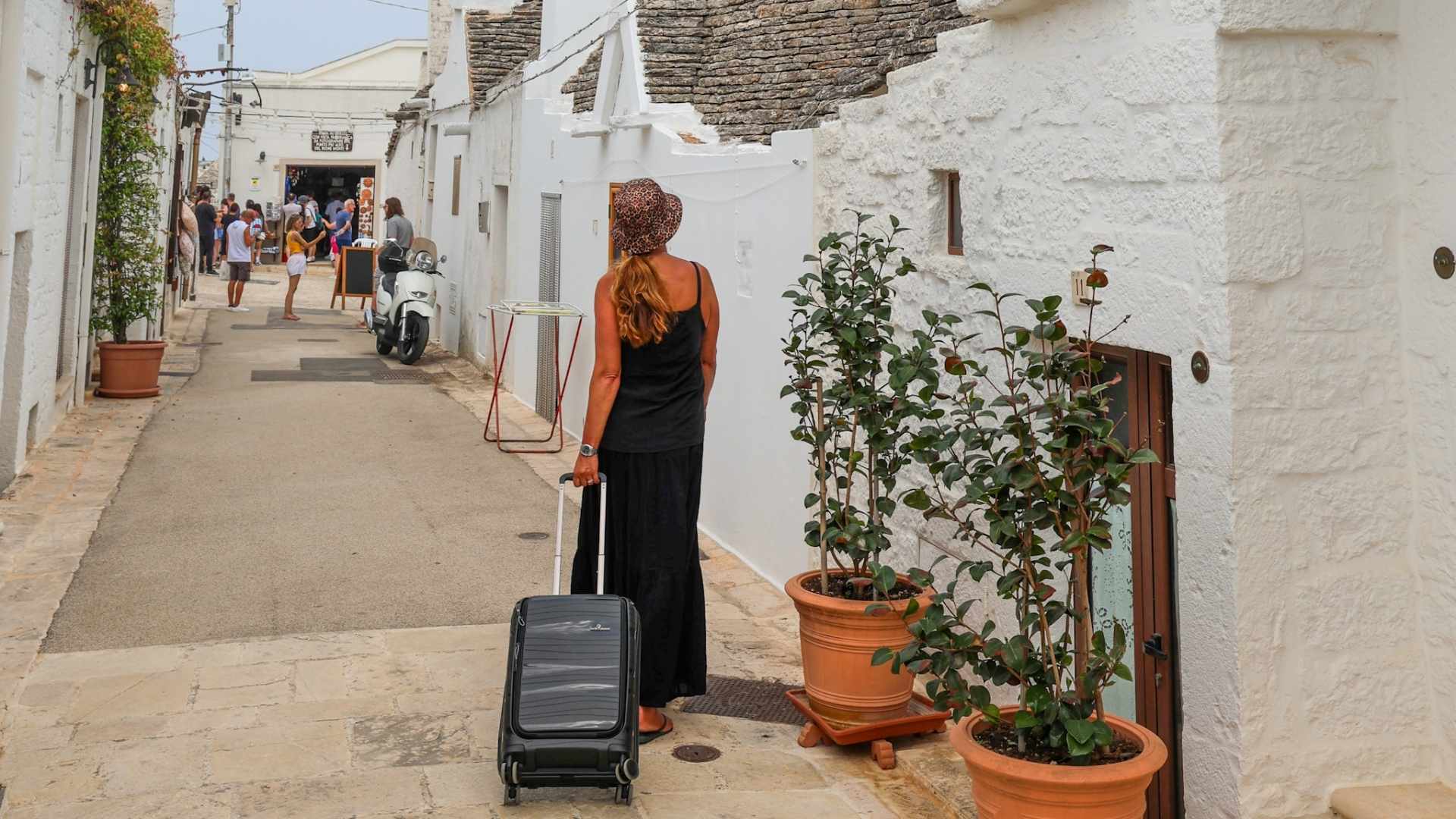 Reiseblogger på trilletur gjennom gatene i Alberobello med trillekoffert fra North Pioneer.