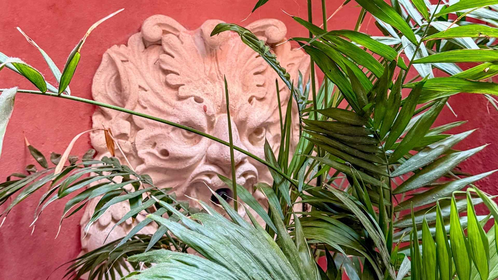 Detalj med løvehode og palme på boutiquehotell i Tarifa. 