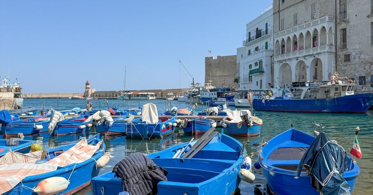 Den gamle havnen i Monopoli med små, blå fiskebåter.