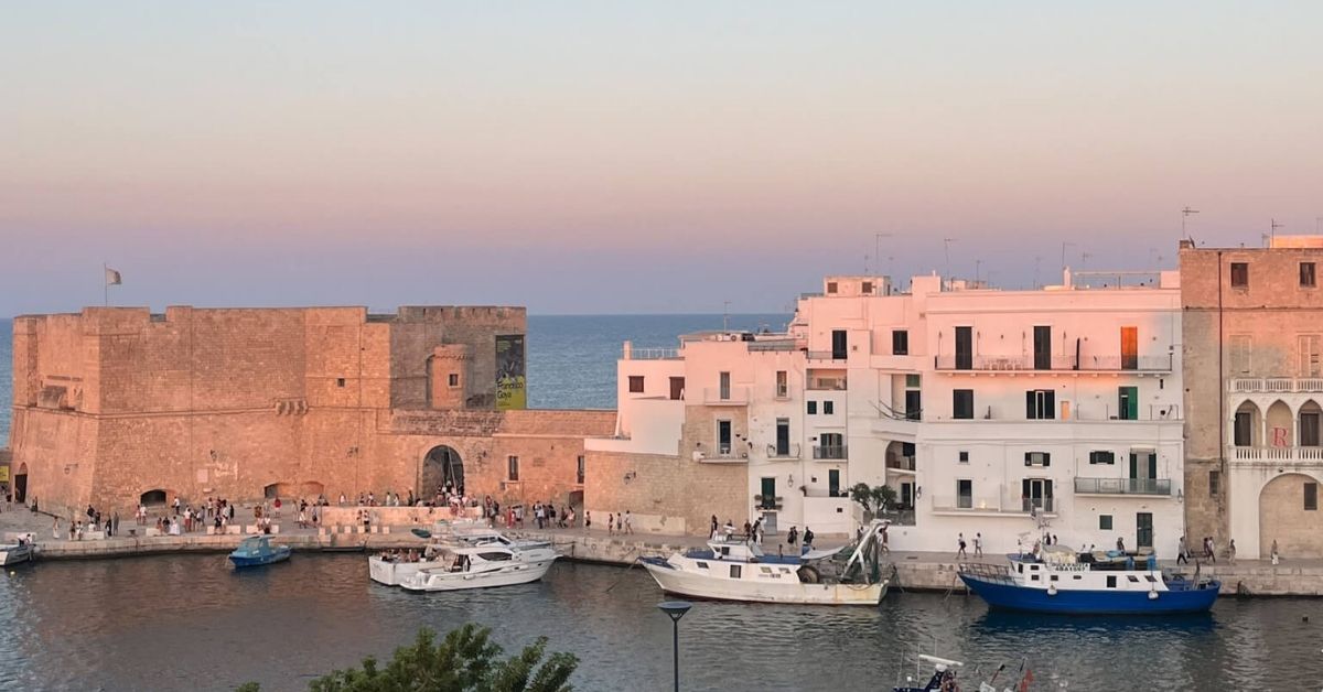 Solnedgang over borgen og havnen i gamlebyen Monopoli i Puglia.
