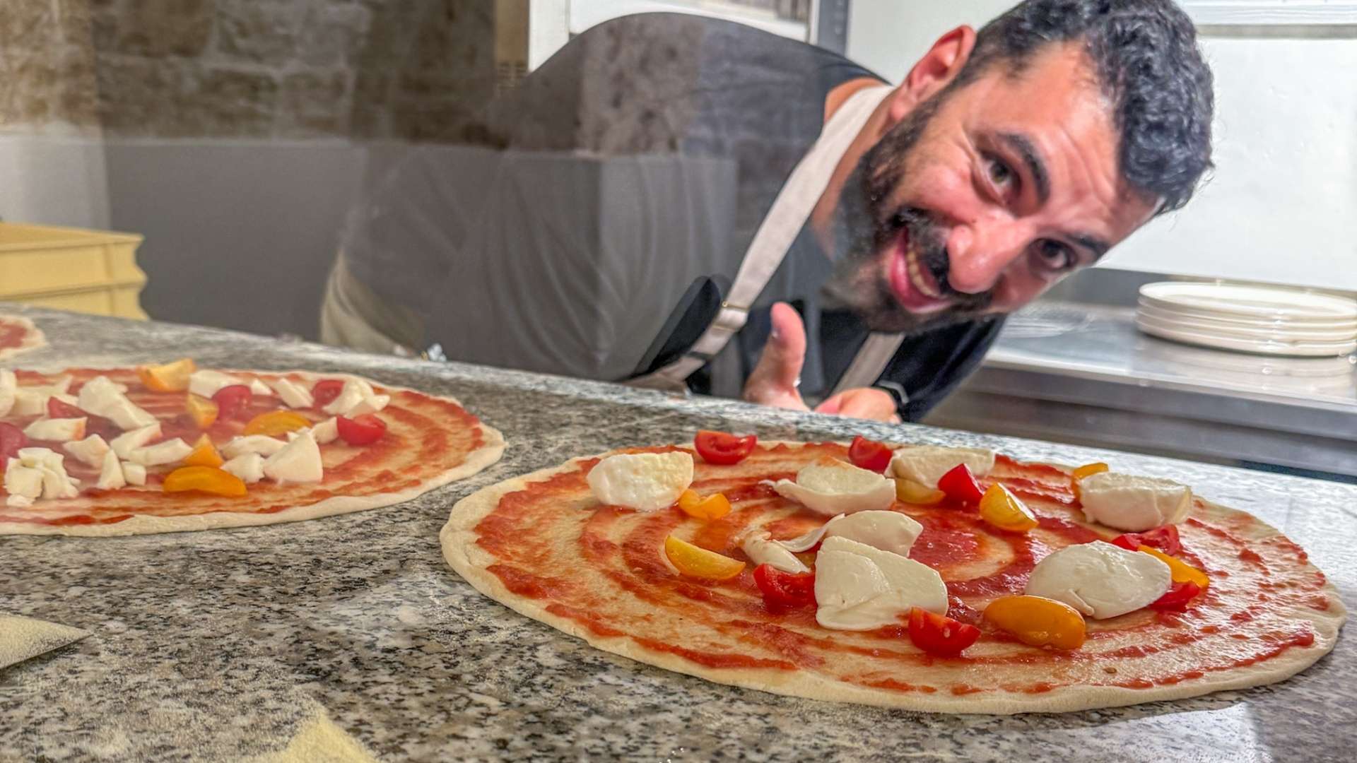 Blid pizzakokk med pizza Margharita i Puglia.
