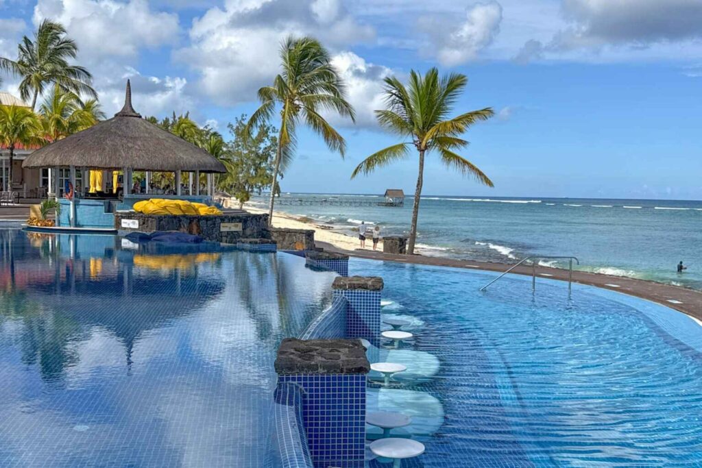 Infinitypool, palmer og strandbar og strand ved Le Méridien Mauritius.