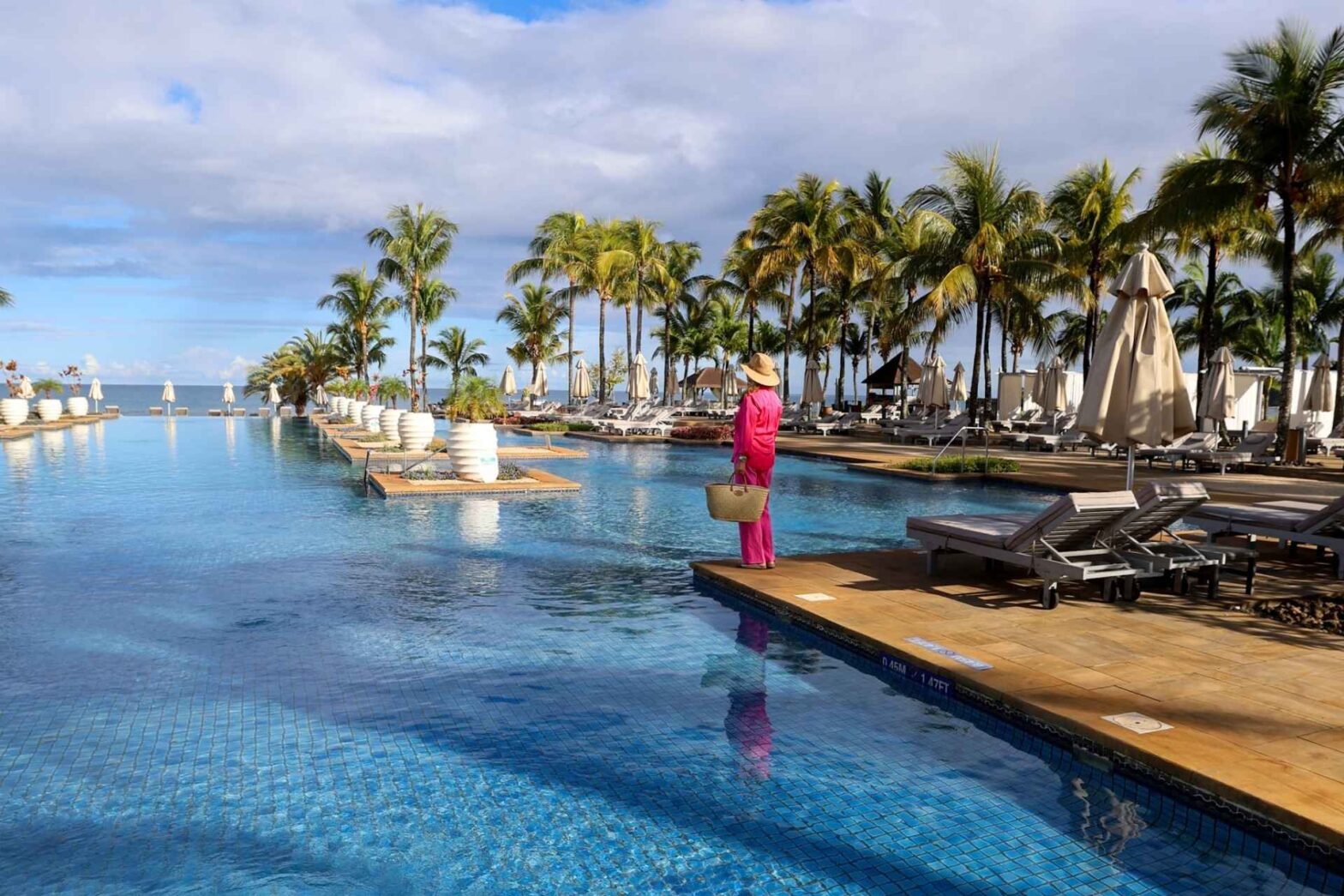 Infinitypool og dame i rosa klær. Westin Mauritius.