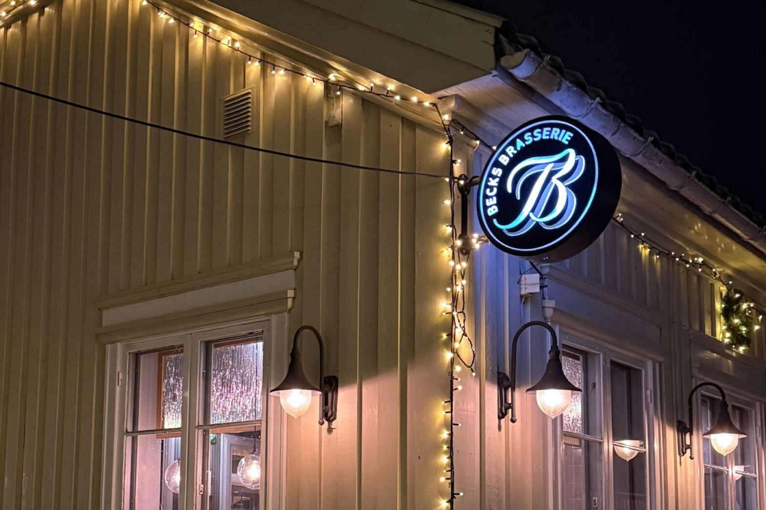 Fasaden til Becks Brasserie & Bar Osebro i Porsgrunn med skilt og varm kveldsbelysning