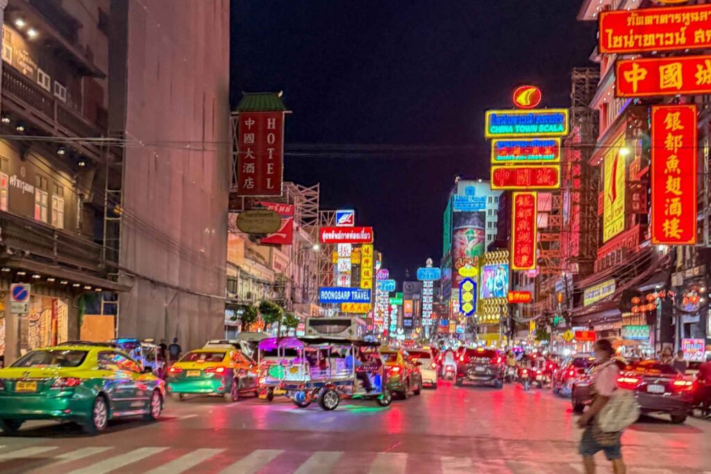 Kveldsstemning i Bangkoks Chinatown med neonlys, tuk-tuker og tett byliv
