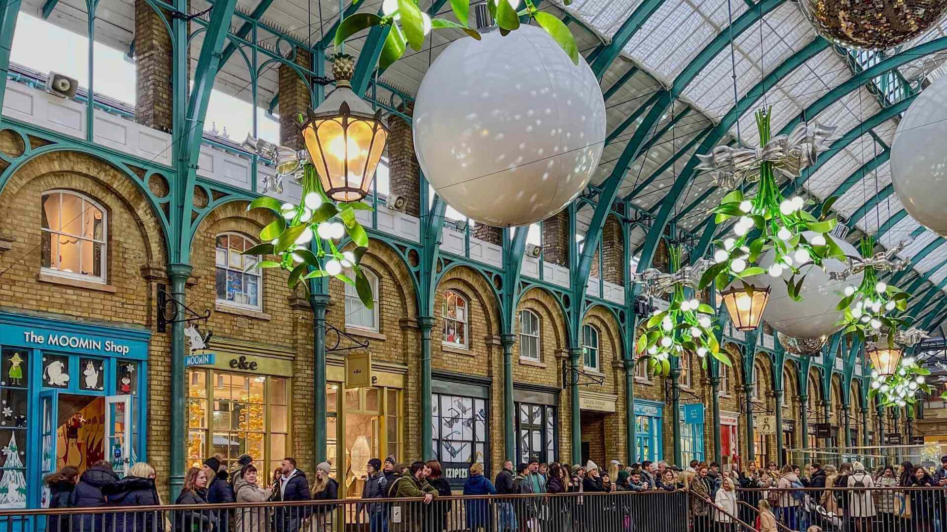 Julepynt og misteltein inne i markedshallen p&aring; Covent Garden i London. 