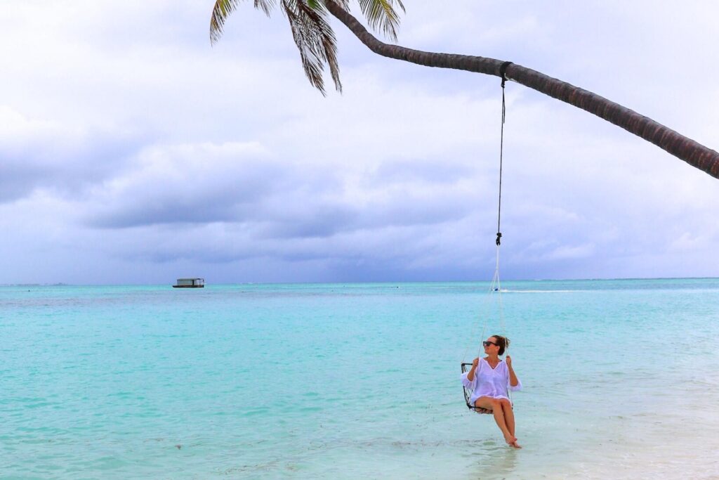 Avslappende strandliv p&aring; Maldivene med turkis lagune og palmehuske