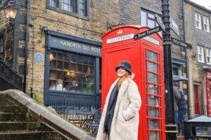 Haworth Old Post Office nå et hyggelig spisested. Dame og rød telefonkiosk.