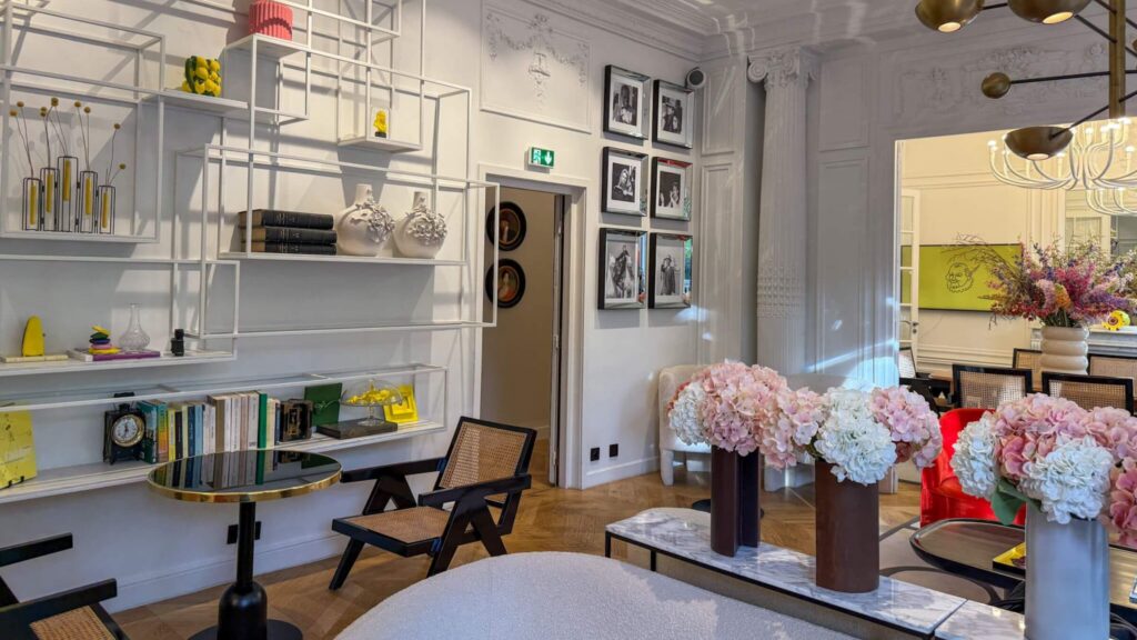 Innbydende fellesrom med sittegrupper, fargerike pyntegjenstander og fargerike blomster i vaser. 