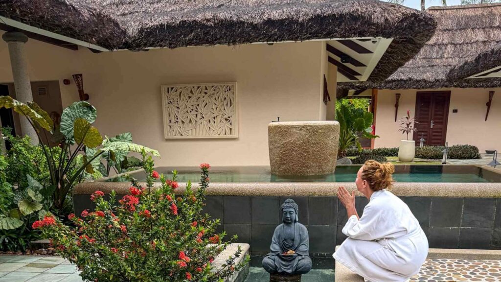 Vakkert og delikat spa på femstjerners resort på Praslin Seychellene. Kvinne har en rolig stund i hagen.