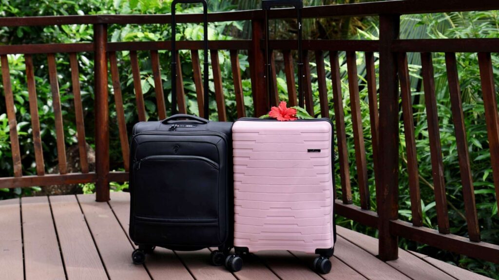 Reise med h&aring;ndbagasje - to kabinkofferter en rosa og en sort