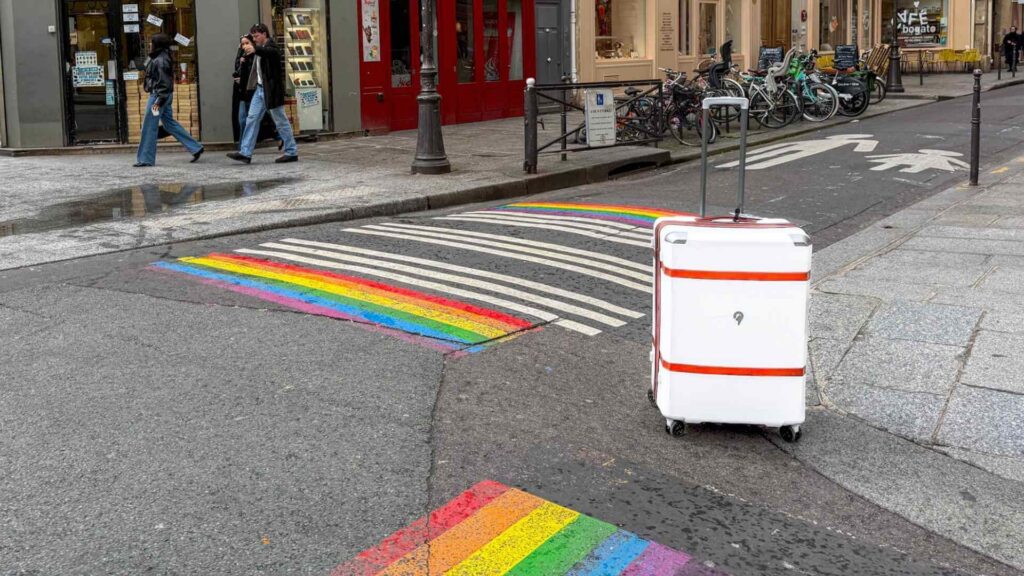 Hvit koffert p&aring; gaten p&aring; storbyferie