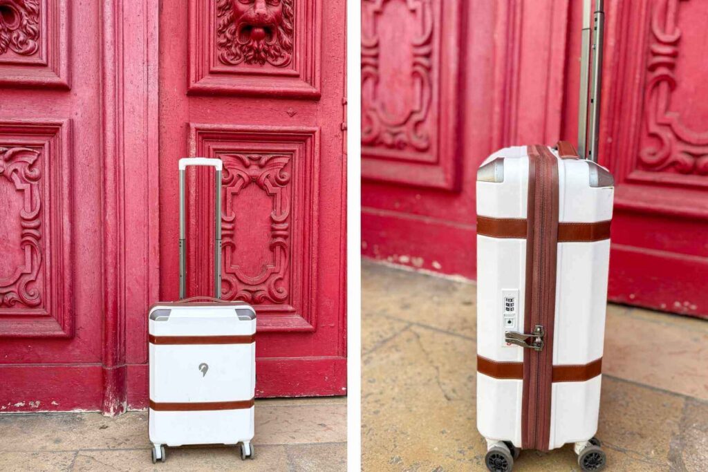 Lekker hvit koffert i vintage stil med brune detaljer mot en lekker r&oslash;d d&oslash;r i Paris