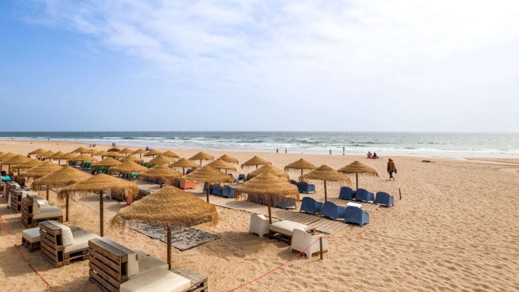 Strand med solstoler og parasoller ved Cascais. 